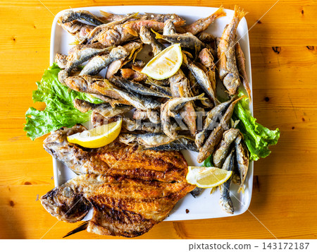 various local fried fishes on plate at wood table 143172187