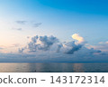 low cumuli cloud in dark blue sky in over calm sea 143172314