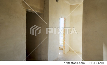 Empty interior room with concrete walls and doorways during new residential construction or renovation project Empty interior room with concrete walls and doorways during new residential construction or renovation project 143173201