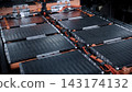 EV car service. Electric vehicle battery pack being serviced or inspected in automotive workshop. Large battery modules and high voltage components. Modern EV power systems. Lithium ion NMC NCA or LFP 143174132