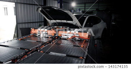 EV car service. Electric vehicle battery pack being serviced or inspected in automotive workshop. Large battery modules and high voltage components. Modern EV power systems. Lithium ion NMC NCA or LFP EV car service. Electric vehicle battery pack being serviced or inspected in automotive workshop. Large battery modules and high voltage components. Modern EV power systems. Lithium ion NMC NCA or LFP 143174135