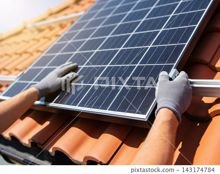 Professional technician installing a modern solar panel system on a residential tiled roof Professional technician installing a modern solar panel system on a residential tiled roof 143174784