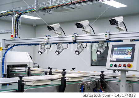Automated visual inspection system on a modern food packaging conveyor belt in a clean factory Automated visual inspection system on a modern food packaging conveyor belt in a clean factory 143174838