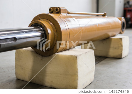 Heavy duty hydraulic cylinder resting on foam blocks in a professional industrial workshop 143174846