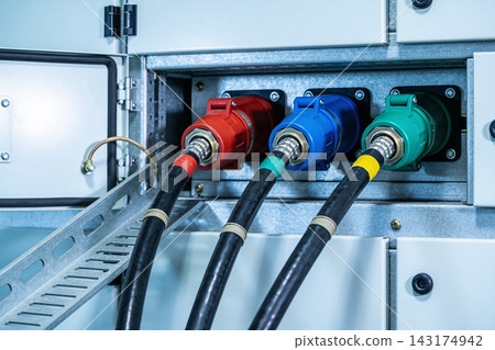 Industrial electrical power distribution panel with three heavy duty color coded cable plugs Industrial electrical power distribution panel with three heavy duty color coded cable plugs 143174942