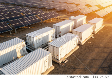 Aerial view of a large solar farm with energy storage containers at golden hour sunset light Aerial view of a large solar farm with energy storage containers at golden hour sunset light 143174976