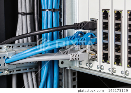 Close up of network cables connected to a high speed server rack in a modern data center facility Close up of network cables connected to a high speed server rack in a modern data center facility 143175129