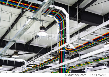 Industrial ceiling view featuring organized multi-colored electrical cables in metal trays Industrial ceiling view featuring organized multi-colored electrical cables in metal trays 143175205