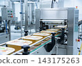 Automated food packaging machine sealing containers on a conveyor belt in a modern factory setting 143175263