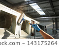 Professional technician cleaning industrial ventilation system with a specialized sponge tool 143175264