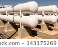 Large white industrial storage tanks for pressurized gas at a modern energy facility site 143175269