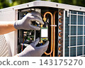 Technician hands installing a smart controller module into an outdoor air conditioning unit 143175270