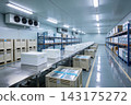 Modern industrial cold storage warehouse with organized shelves and white shipping containers 143175272