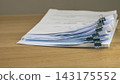 Stacked business documents secured with binder clips 143175552