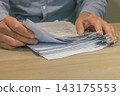 Office worker hands sorting paper documents 143175553