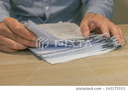 Office worker hands sorting paper documents Office worker hands sorting paper documents 143175553
