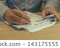 Office worker hands sorting paper documents 143175555