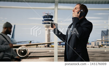 Agitated man on business trip annoyed during phone call in airport terminal. Angry businessman speaks on smartphone in airport terminal, having disagreement dispute with business partners Agitated man on business trip annoyed during phone call in airport terminal. Angry businessman speaks on smartphone in airport terminal, having disagreement dispute with business partners 143176009