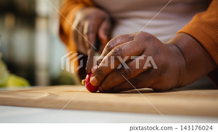 Close up of food influencer doing meal prep for a salad bowl, cutting radish and other vegetables on the cutting board. Filming a video with the cooking process and culinary advice. Close up of food influencer doing meal prep for a salad bowl, cutting radish and other vegetables on the cutting board. Filming a video with the cooking process and culinary advice. 143176024