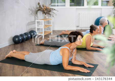 Group of elderly woman doing yoga on mat in studio 143176344