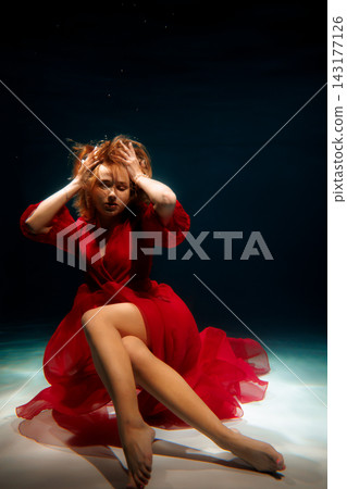 Caucasian storyteller submerged in red dress, poetic portrait Caucasian storyteller submerged in red dress, poetic portrait 143177126