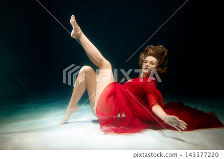 Athletic dancer executes lift beneath water with controlled movements Athletic dancer executes lift beneath water with controlled movements 143177220