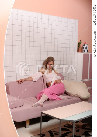 Chic individual photographs herself on sofa with warm lighting and decor Chic individual photographs herself on sofa with warm lighting and decor 143177502