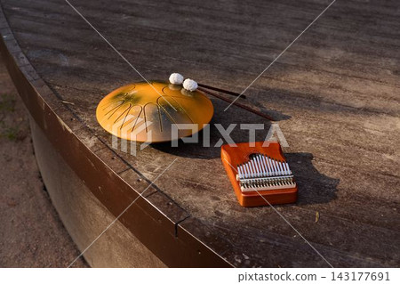 Sunshade And Instrument Relax. Calm Late Day Scene Featuring Musical Accessories And Textured Surroundings Sunshade And Instrument Relax. Calm Late Day Scene Featuring Musical Accessories And Textured Surroundings 143177691