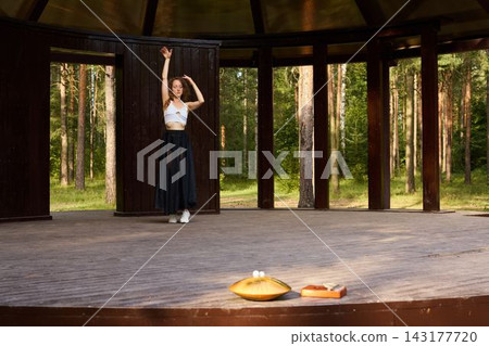 Solitary dancer trains during sunset amidst forest surroundings Solitary dancer trains during sunset amidst forest surroundings 143177720