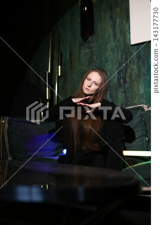 Caucasian female examining LED gadget in minimalistic setting Caucasian female examining LED gadget in minimalistic setting 143177730