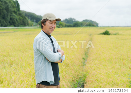 一位農民站在稻田前 一位農民站在稻田前 143178394