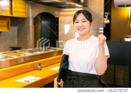 Female university student working at a sushi restaurant Female university student working at a sushi restaurant 143178737