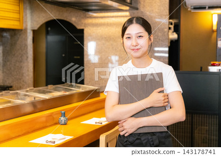 Female university student working at a sushi restaurant Female university student working at a sushi restaurant 143178741