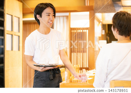 A young male part-time worker who serves customers. A young male part-time worker who serves customers. 143178931