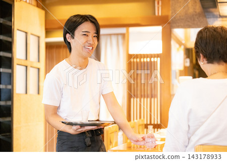 A young male part-time worker who serves customers. A young male part-time worker who serves customers. 143178933