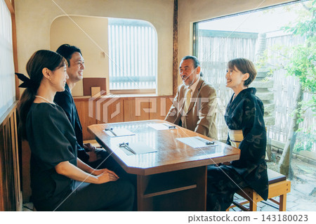 A couple meeting their parents in a private room. A couple meeting their parents in a private room. 143180023