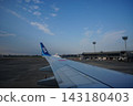 Taken from inside an airplane as it takes off, with the airplane wing and blue sky in the background. 143180403