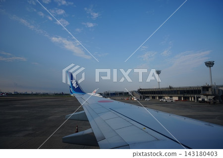 Taken from inside an airplane as it takes off, with the airplane wing and blue sky in the background. Taken from inside an airplane as it takes off, with the airplane wing and blue sky in the background. 143180403