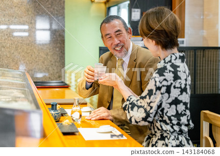 一對老年夫婦在壽司店舉杯慶祝 143184068