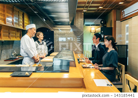 一對情侶在壽司店與壽司師傅聊天。 143185441