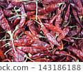 Full frame heap of dried red chili peppers with stems used as pungent spice in culinary dishes and various hot food preparation recipes. 143186188