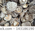 Group of dried organic shiitake mushrooms in clear container display for nutritious plant based cooking or medicinal food ingredient preparation use. 143186190