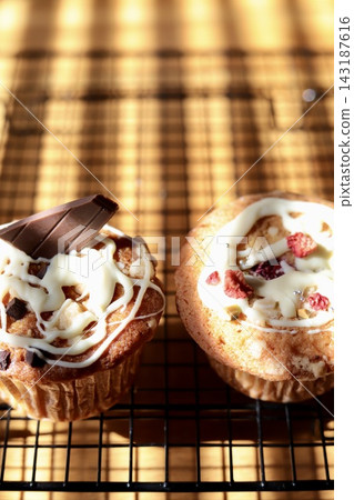 Berry muffins and chocolate banana muffins in the shadow of the blinds Berry muffins and chocolate banana muffins in the shadow of the blinds 143187616