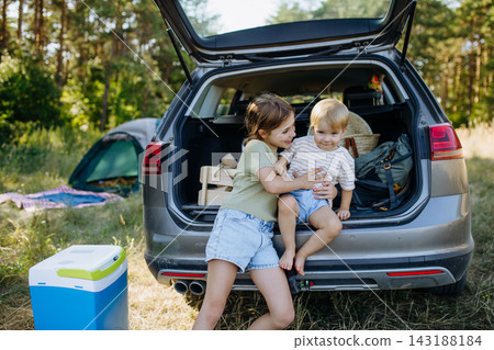 Girls sitting in car trunk at the beginning of a camping trip. Girls sitting in car trunk at the beginning of a camping trip. 143188184