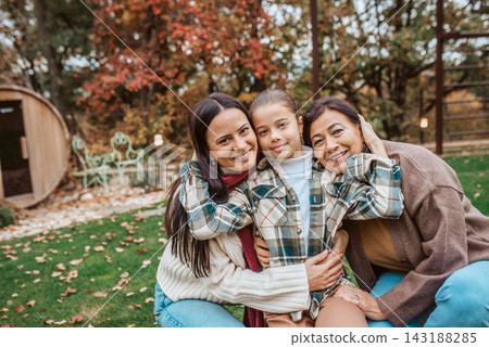 Mother, grandmother and granddaugter standing in autumn garden. Mother, grandmother and granddaugter standing in autumn garden. 143188285