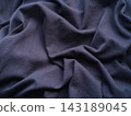A close-up shot of a soft wrinkled dark blue jersey fabric 143189045