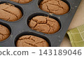 A close-up shot of freshly baked oval breads with cracked tops inside a silicone baking pan. 143189046