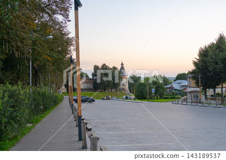 Historical tower stationary, in urban park, with historical tower, streetlights, cars, buildings, from a street level perspective, with green, gray accents, and serene mood, nearby objects. 143189537