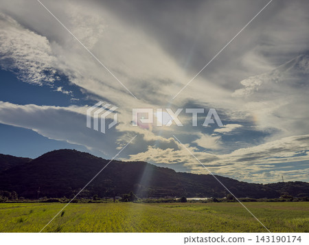 陽光穿透雲層,灑落在鄉村景觀中。 陽光穿透雲層,灑落在鄉村景觀中。 143190174