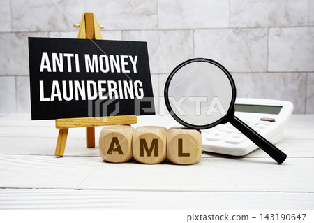 AML Anti Money Laundering text with calculator magnifying glass and on wooden background AML Anti Money Laundering text with calculator magnifying glass and on wooden background 143190647